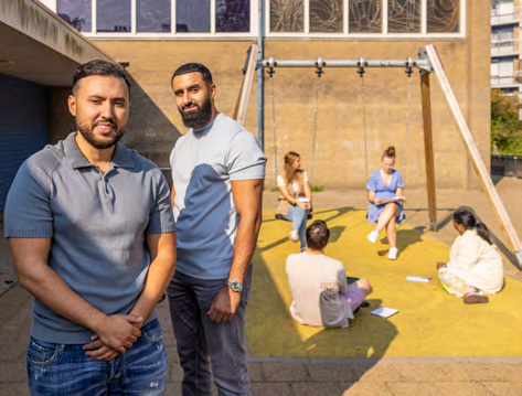 Active bewoners samen bij de schommels in een speeltuintje.