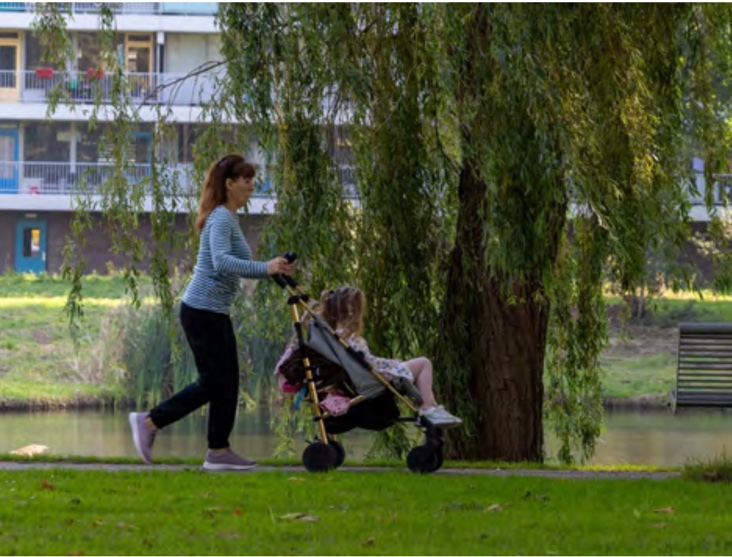 Bewoonster loopt met kinderwagen langs het water